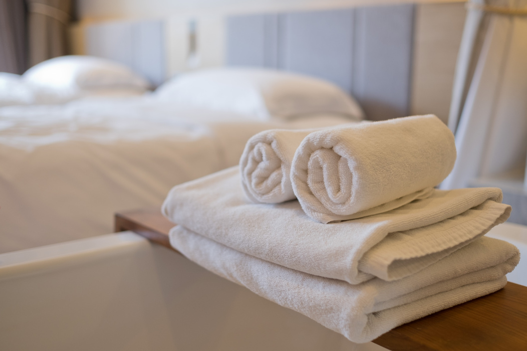 cleaning hotel, bath towel on white bed, room service